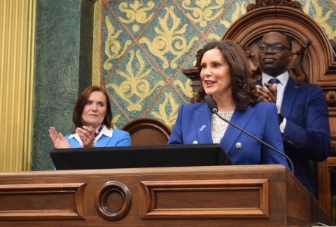 Michigan Governor Gretchen Whitmer stands at a podium during a State of the State address 