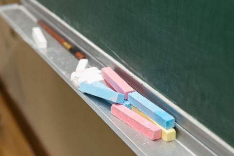 Closeup of blank green blackboard with pieces of chalks