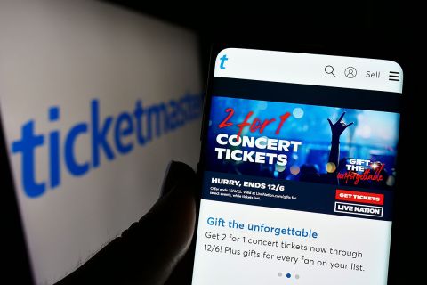 Person holding smartphone with webpage of US company Ticketmaster Entertainment Inc. on screen in front of logo. 