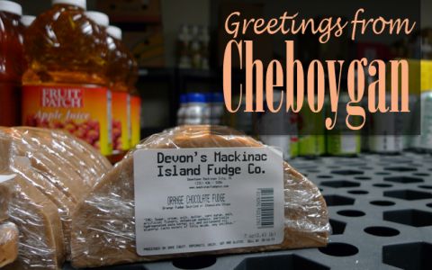 A postcard that says "Greetings From Cheboygan" with a picture of Mackinac Island fudge