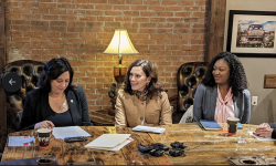 three woman sitting at a table