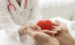 doctor and patient hands holding red heart