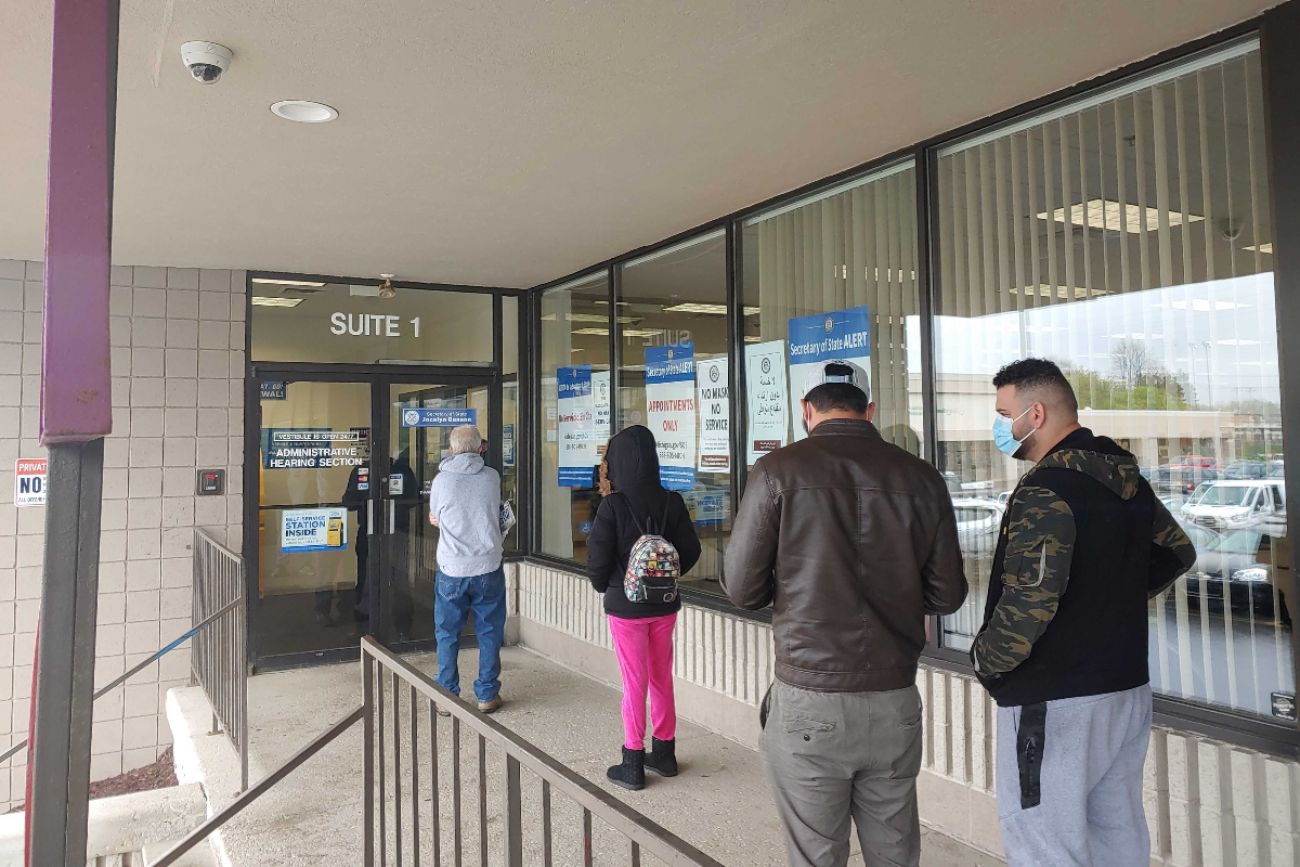 Customers wait in line outside the Secretary of State’s Lansing Branch