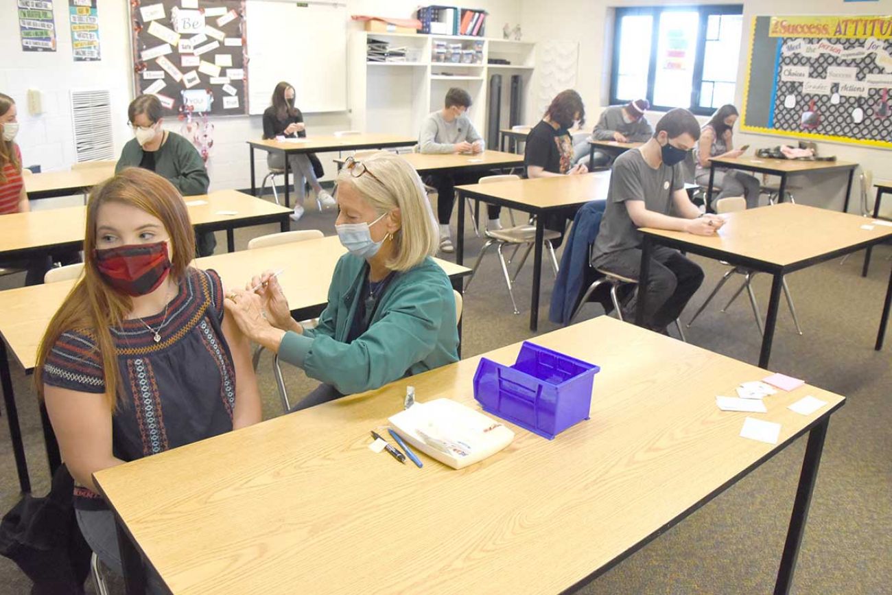 Annelle Kastor, a public health nurse with the Grand Traverse County Health Department, administers a Covid-19 vaccine to Alexis Sattler, 16, at Kingsley High School Thursday