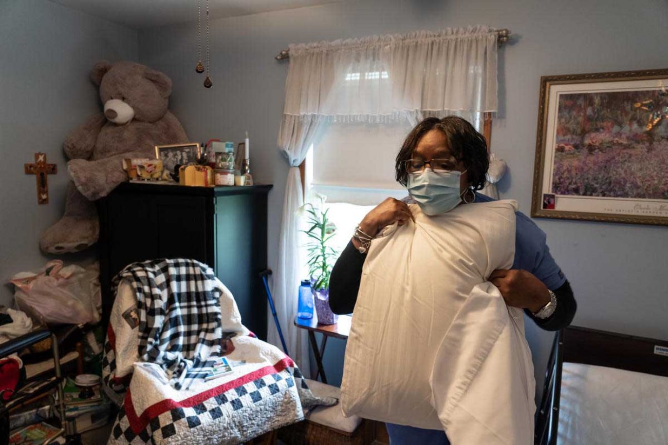 Excellacare Care Provider Sarah Sutherlin changes sheets and pillow cases while cleaning the room of her client Carmela Palamara, 92, of Brownstown at Palamara's home in Brownstown on Wednesday, April 14, 2021. Sutherlin has done in home personal care and homemaking to help her live independently three days-a-week for the last three years.