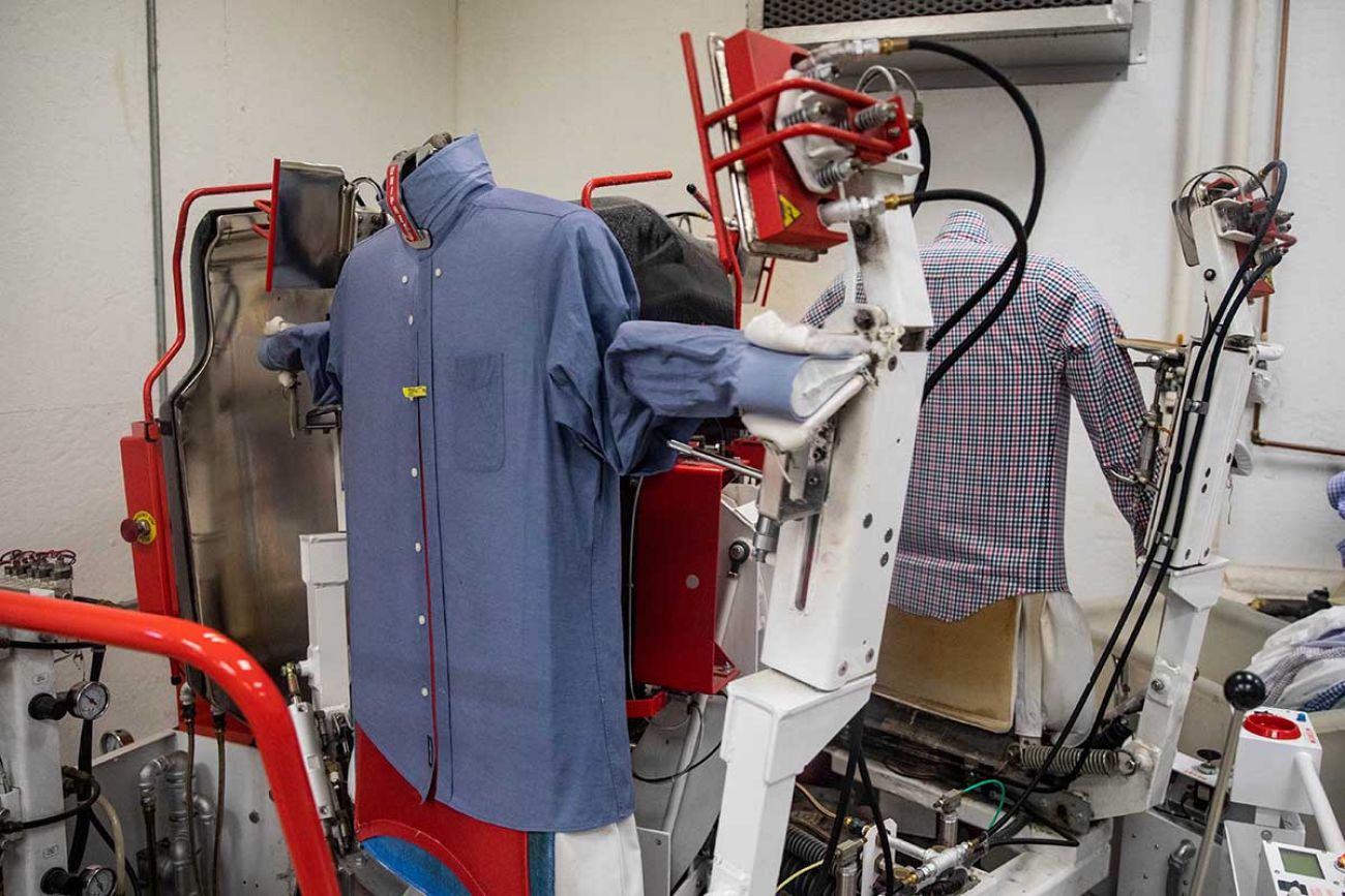 A machine presses and dries dress shirts.