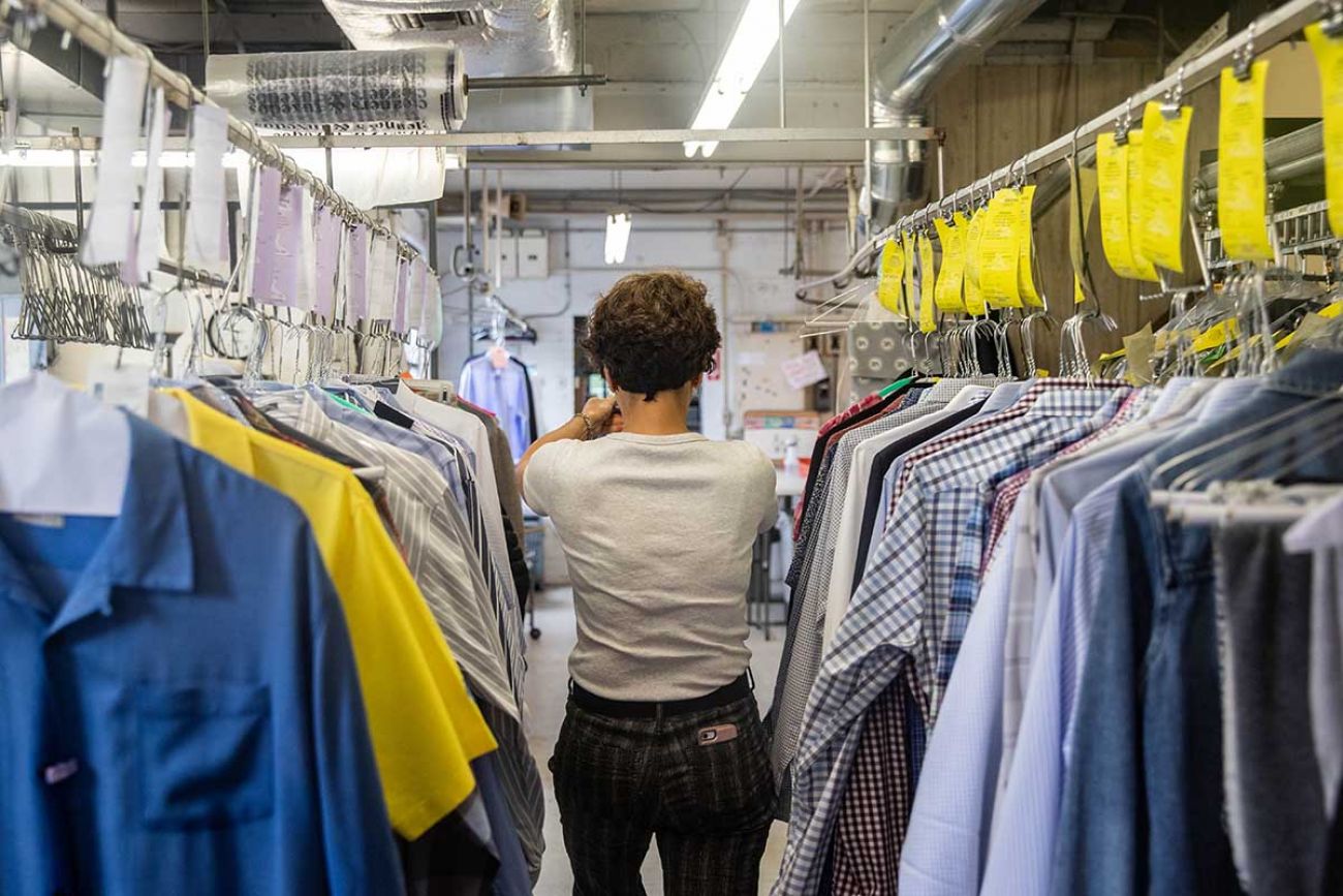 Becky Afendoulis Trierweiler walks through lines of shirts on Monday morning, May 24.