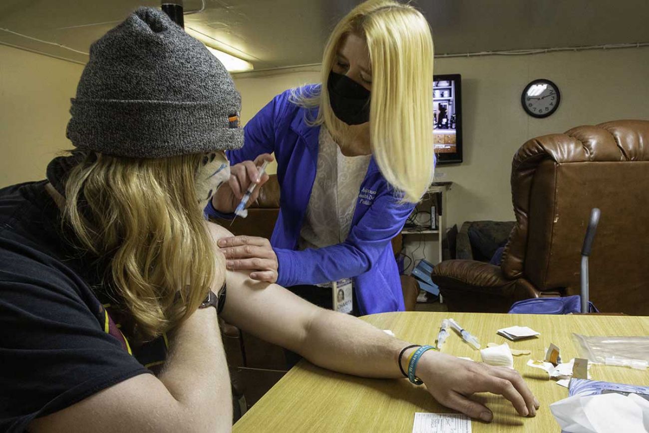 Public health nurse Charity Zimmerman, 48, administering vaccination to freighter Lee Tregurtha crew member Gregory Myers, 26.