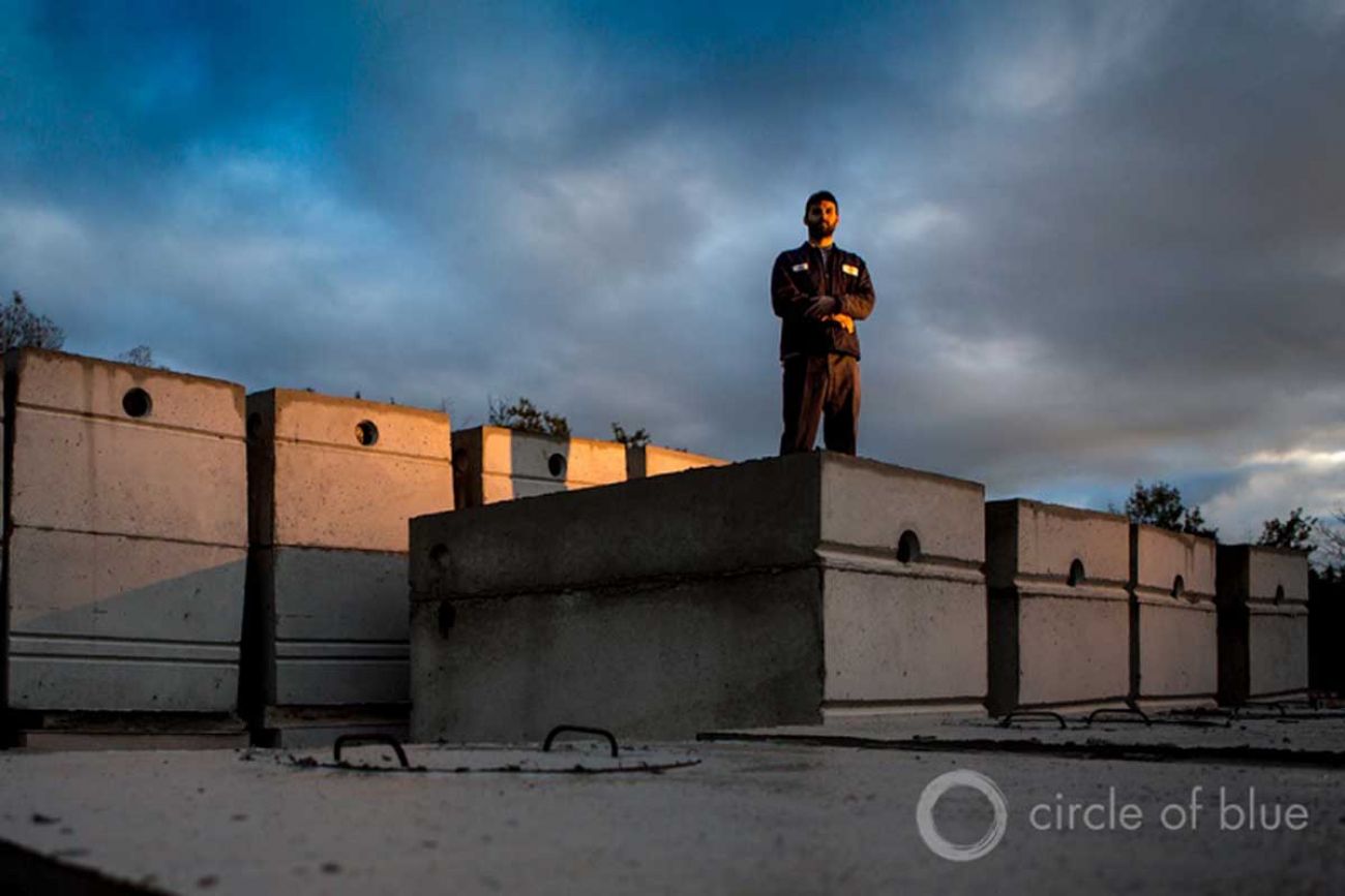 Jacob Stachnik, a worker at Concrete Service in Traverse City, Michigan, stands on a stack of septic tanks