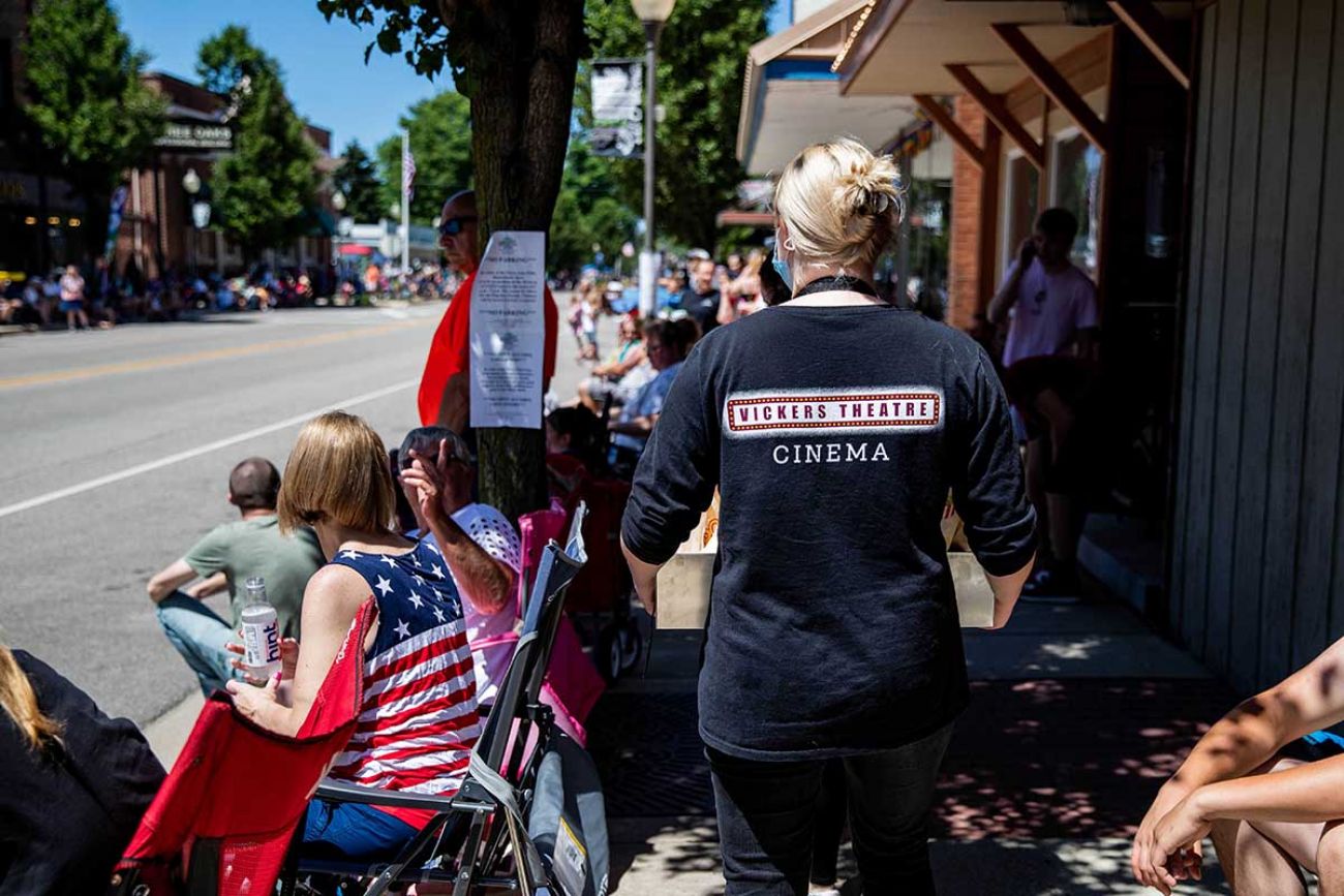 Olive Adnson passes out free popcorn outside Vickers Theater to people watching the Flag Day Parade on Sunday, June 13, in Three Oaks.