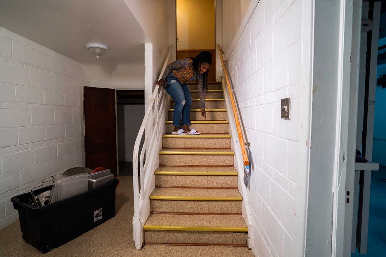 Latrice Taylor points to how high the water rose in her basement after several inches of rain flooded the city.