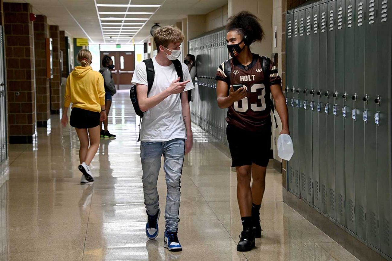 students in the hallway with masks