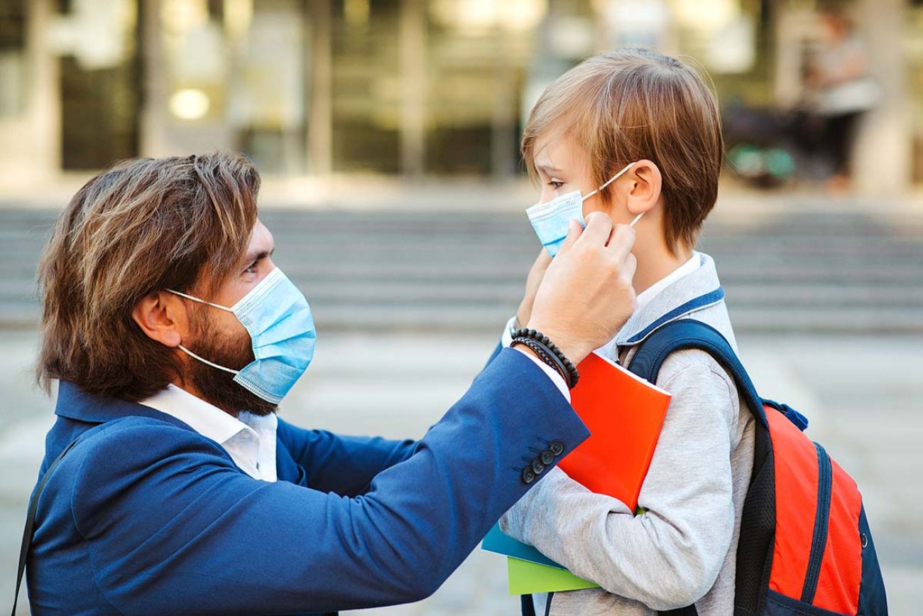 man putting kids with mask on