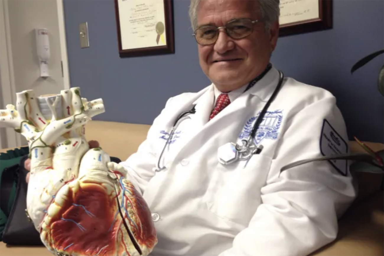 doctor next to a model of a heart