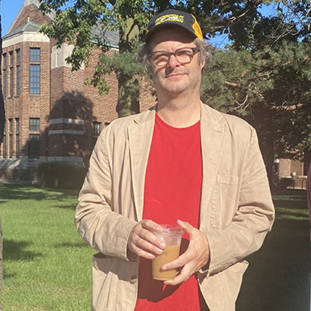 man standing holding coffee 