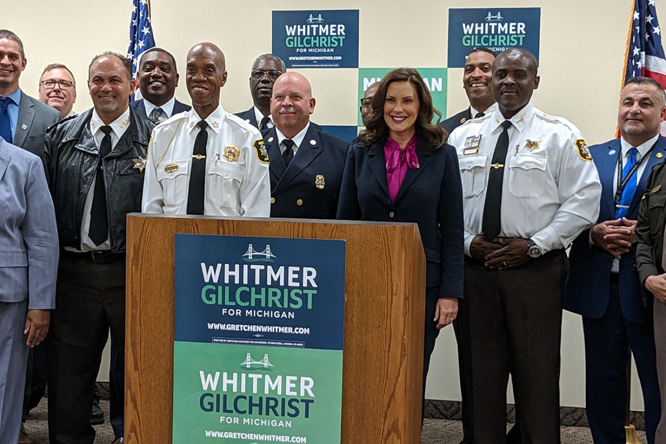 whitmer standing by a lot of law enforcement officers