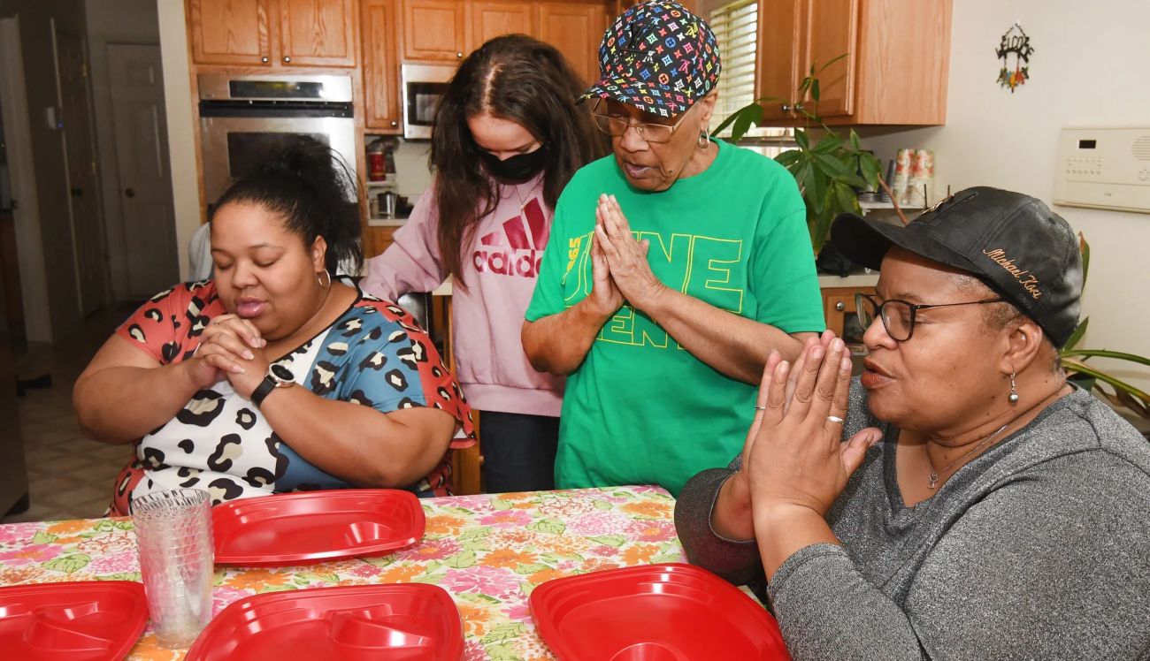 people praying around the table