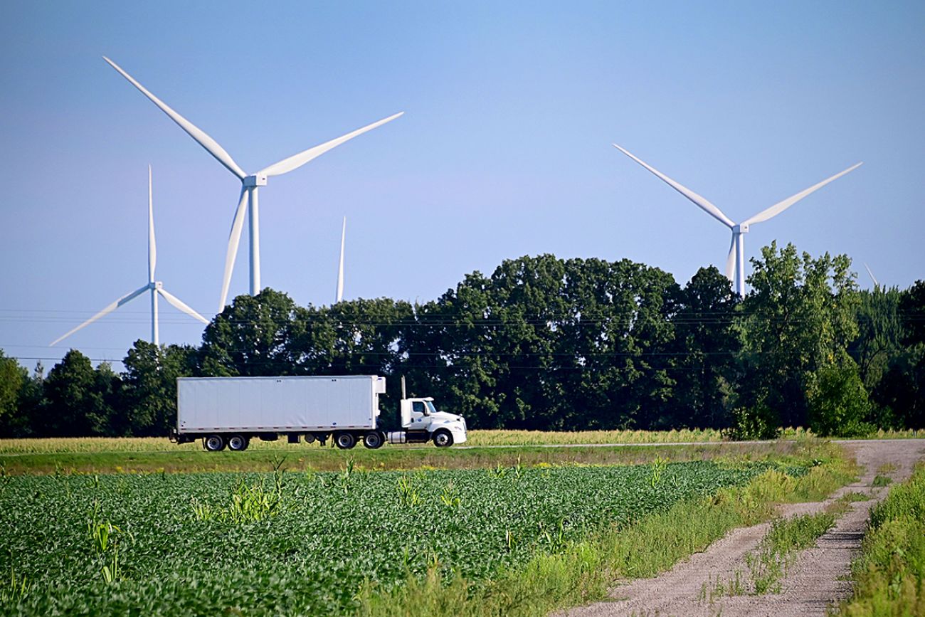truck driving past wind turbines