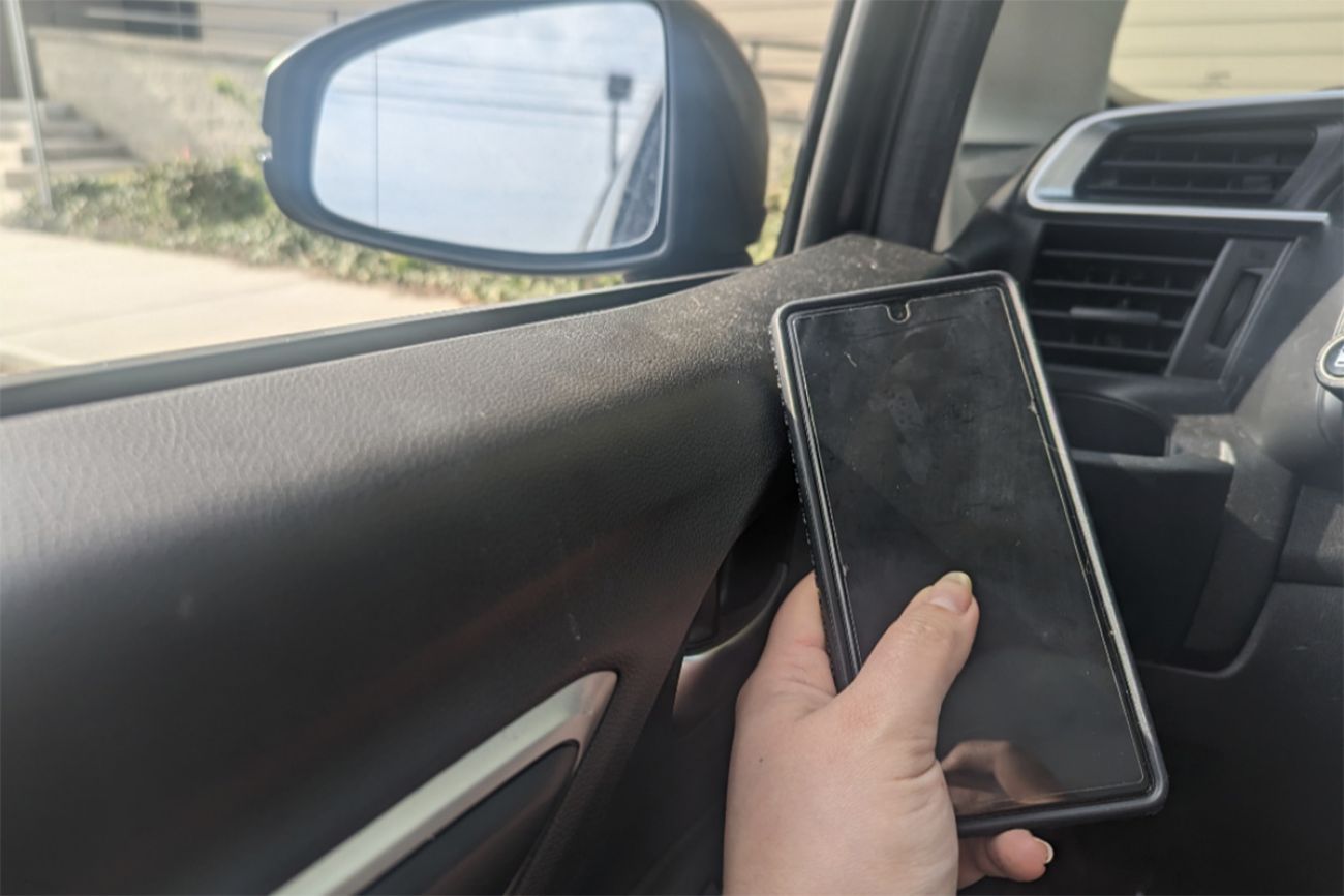 someone holding phone in car