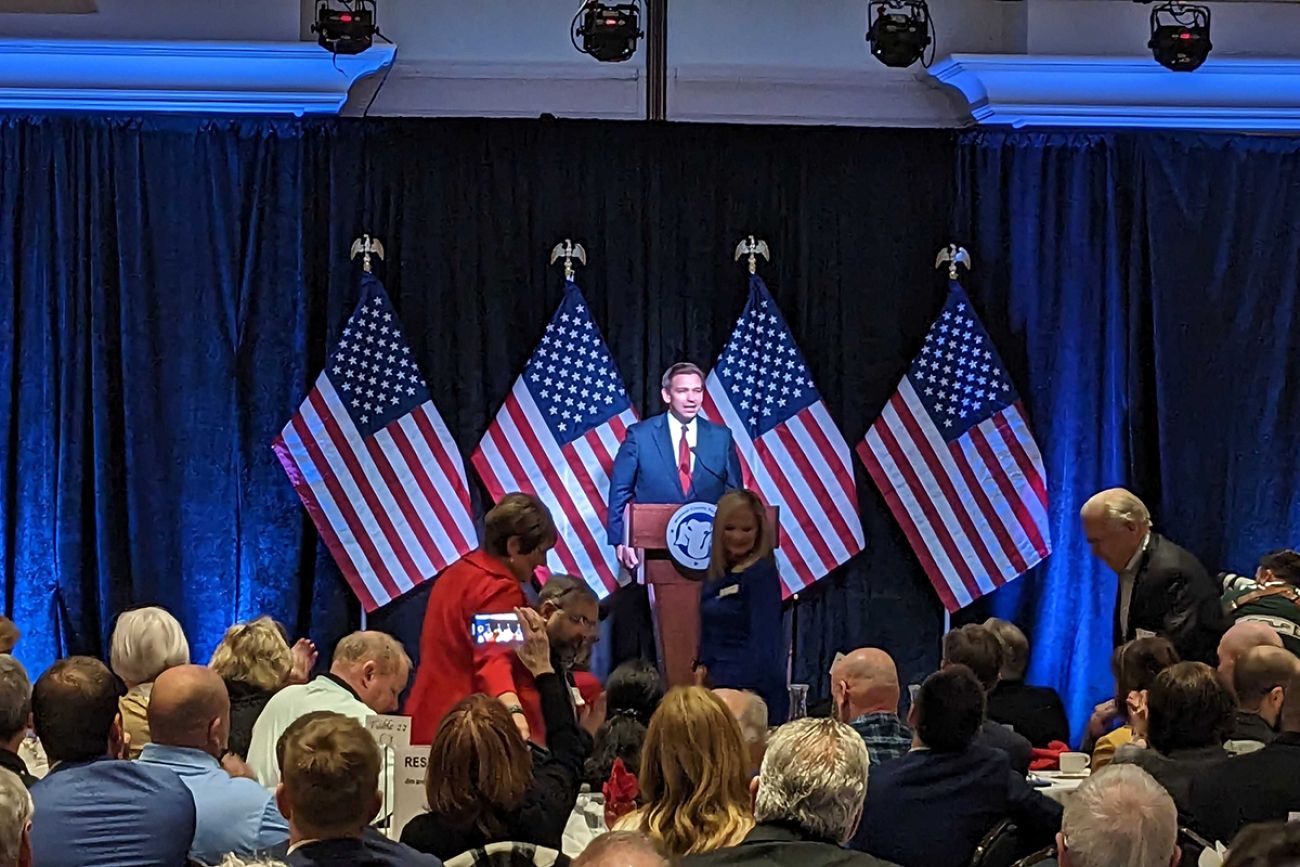 Florida Gov. Ron DeSantis on stage with a hall full of people