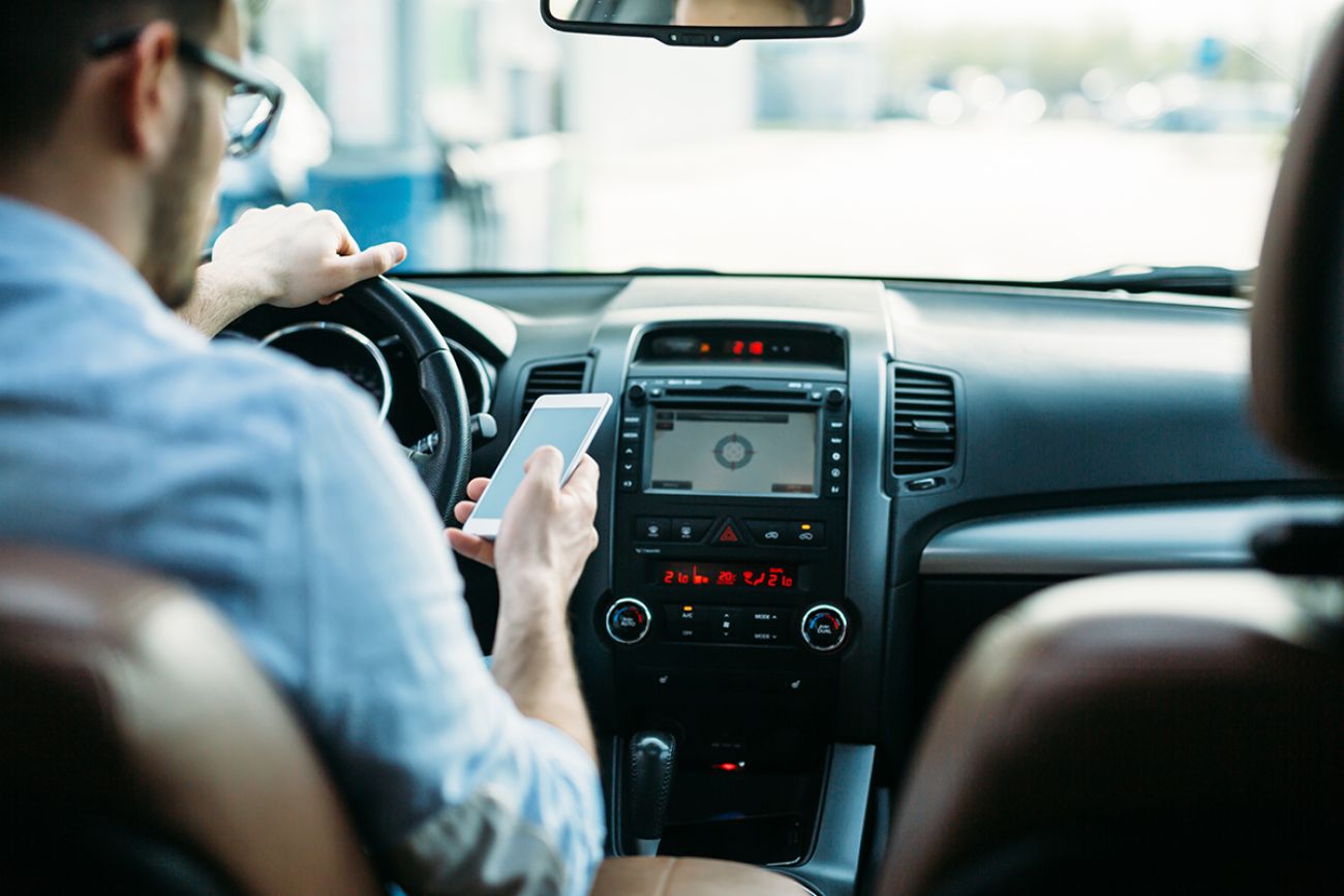 Man texting on phone while driving