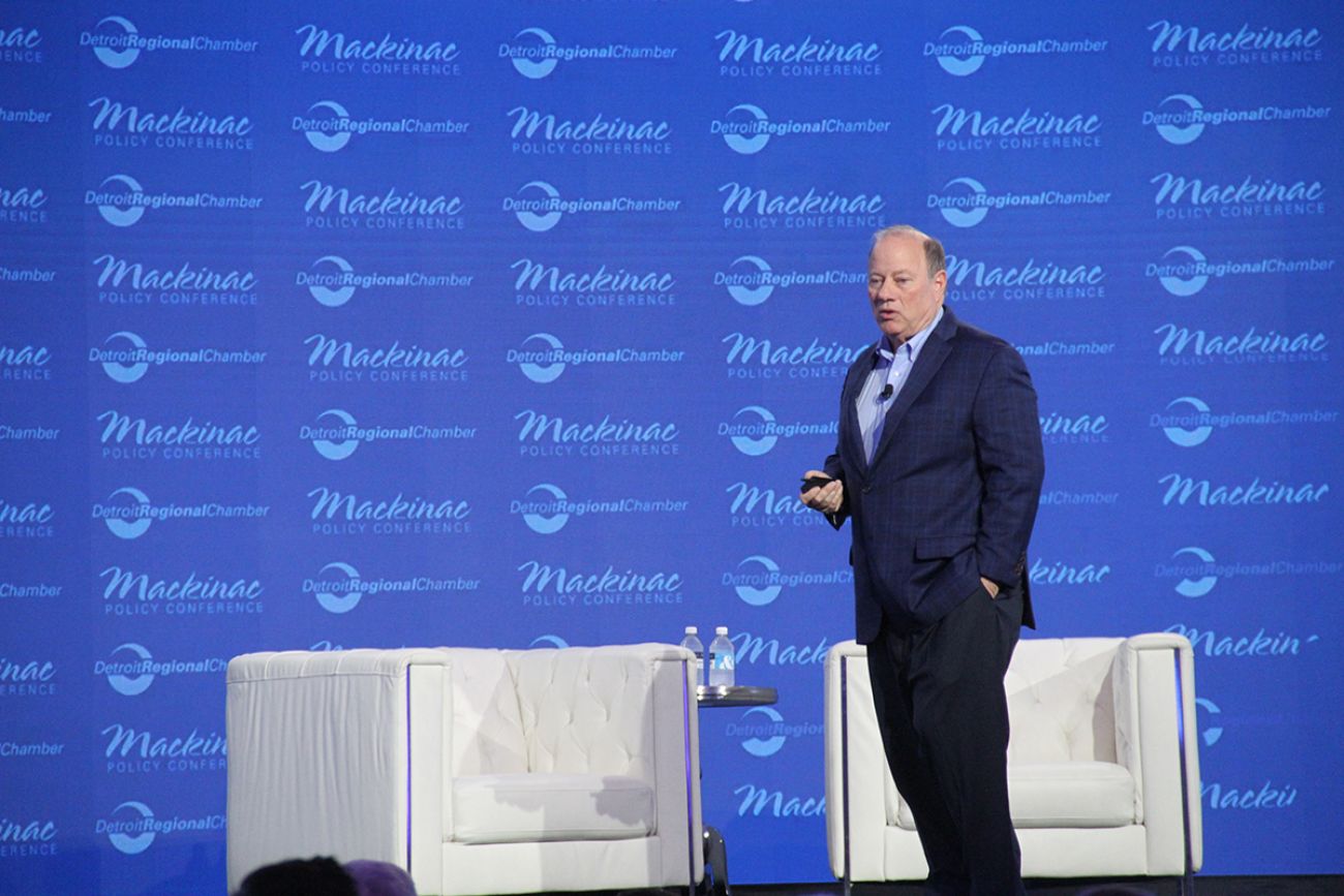 Detroit Mayor Mike Duggan on a stage with a blue background