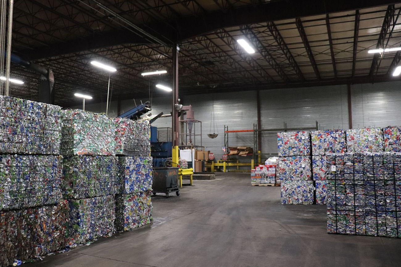barrels of Aluminum cans and bottles pressed into bricks in a warehouse