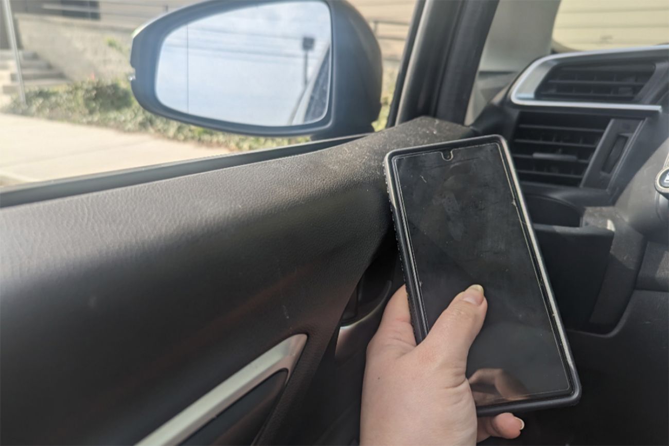 person holding cell phone in car