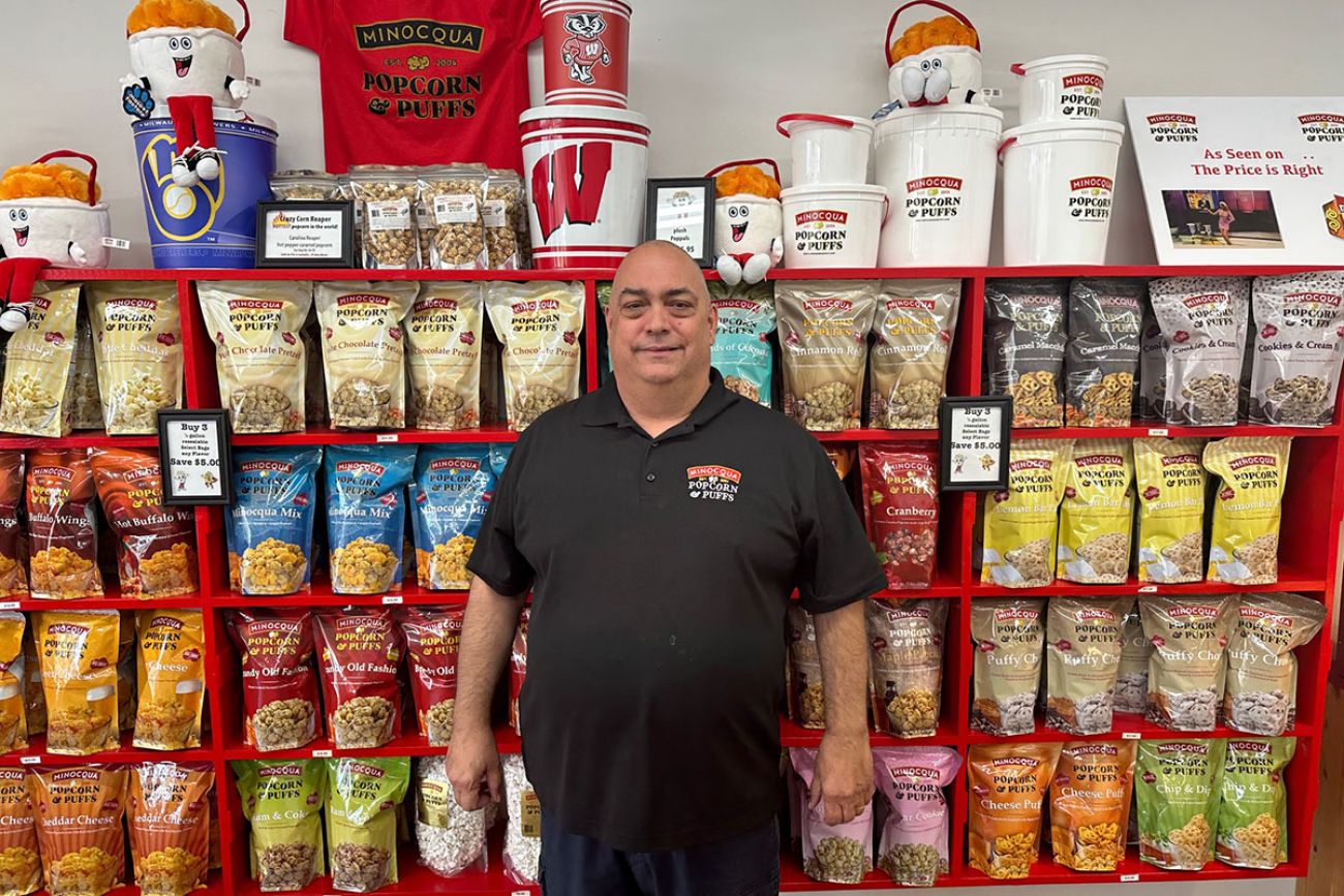 Jim Gleich standing in front of red shelf with popcorn-related products