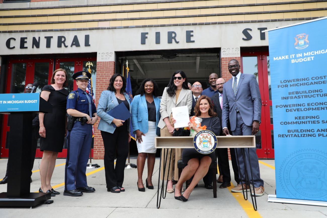 Michigan lawmakers smile in front of fire station