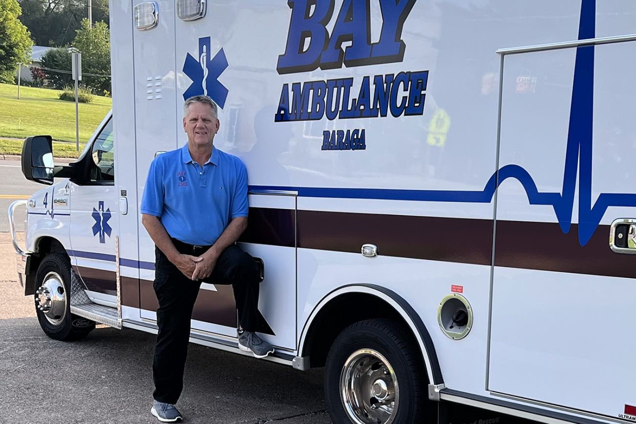 Gary Wadaga standing in front of an ambulance 