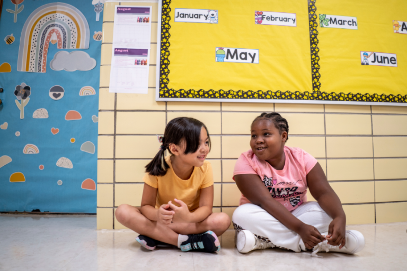 Two girls sit in the hallway