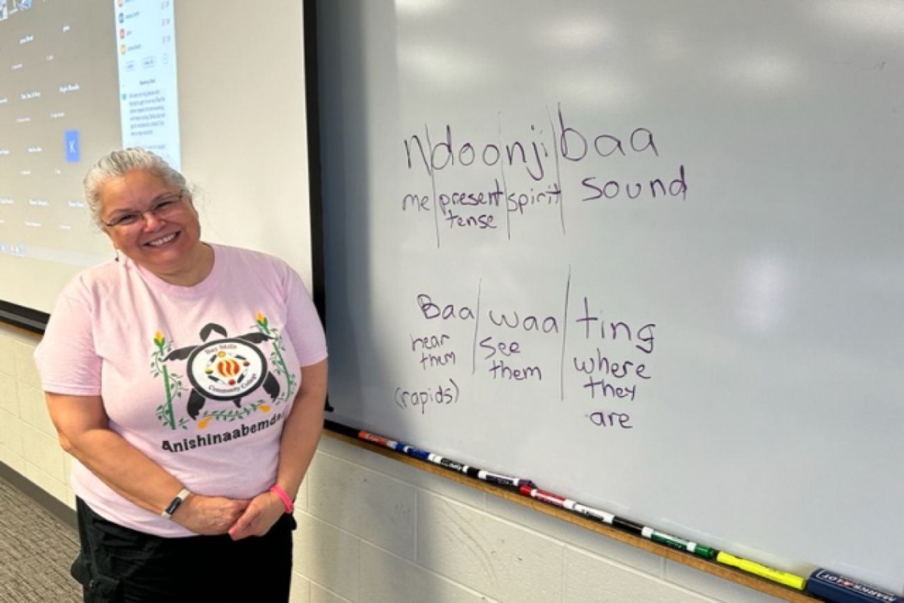 Woman stands in front of board