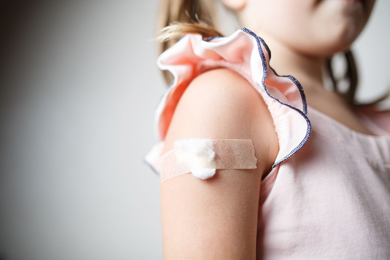 little girl with plaster on the shoulder from the injection