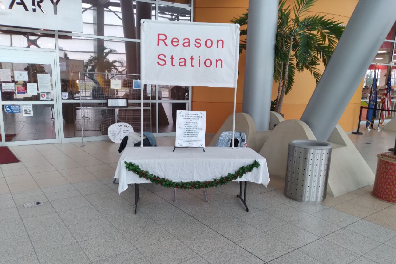Table with a sign that says "Reason Station"