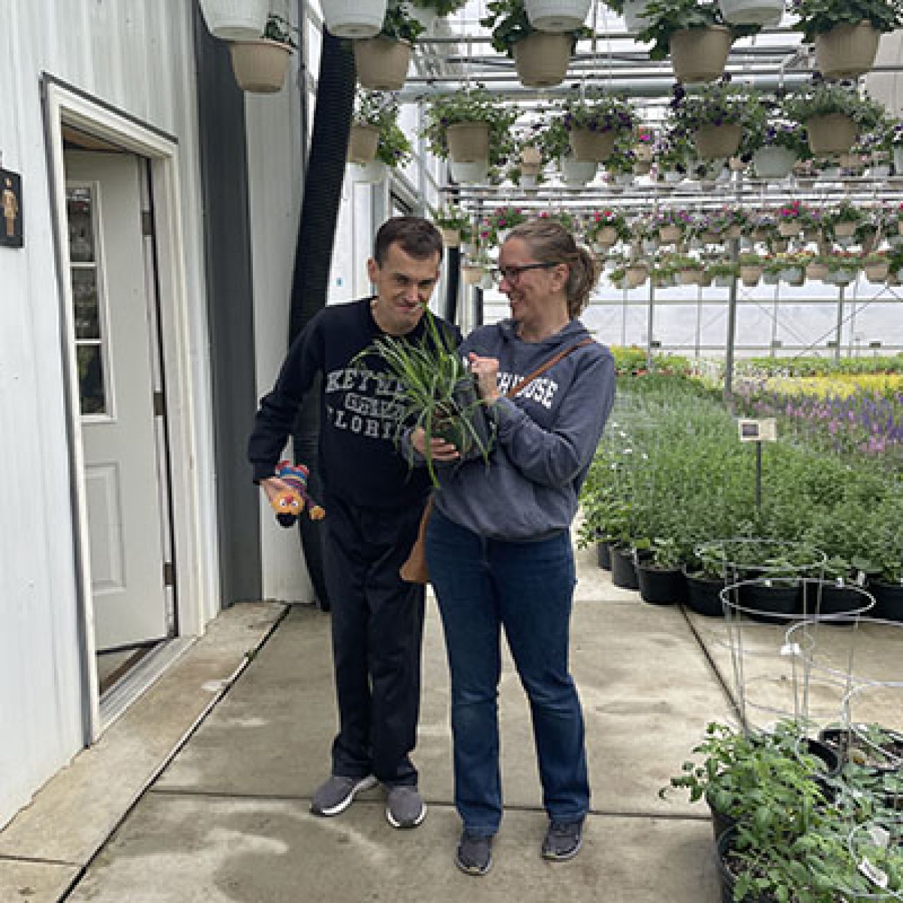 two people standing in a greenhouse