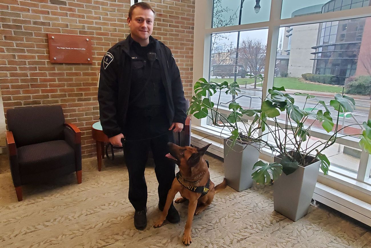 man standing next to a German Shepard
