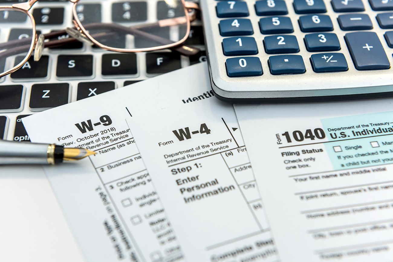 tax forms with with laptop and calculator