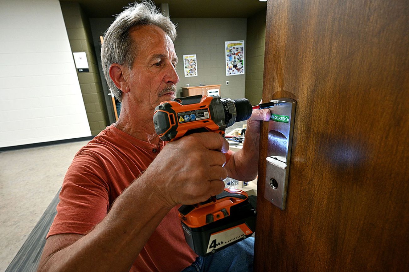 man putting new locks on doors