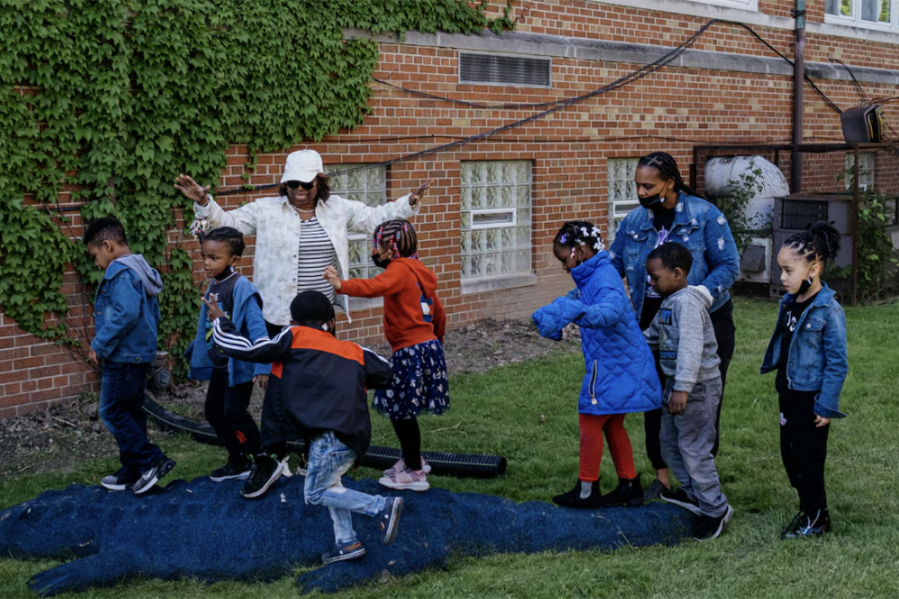 students outside playing with a teacher