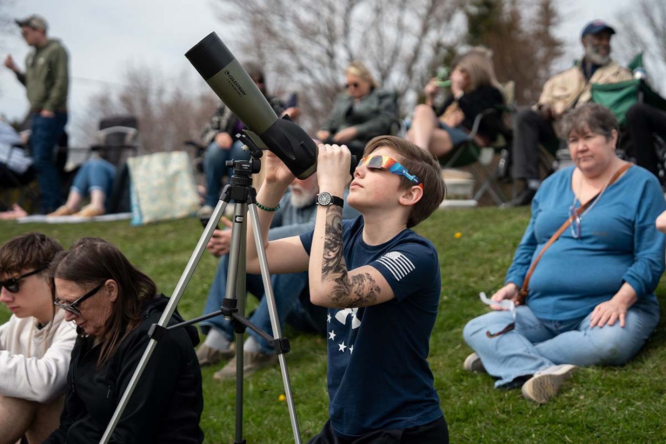 person looking at telescope