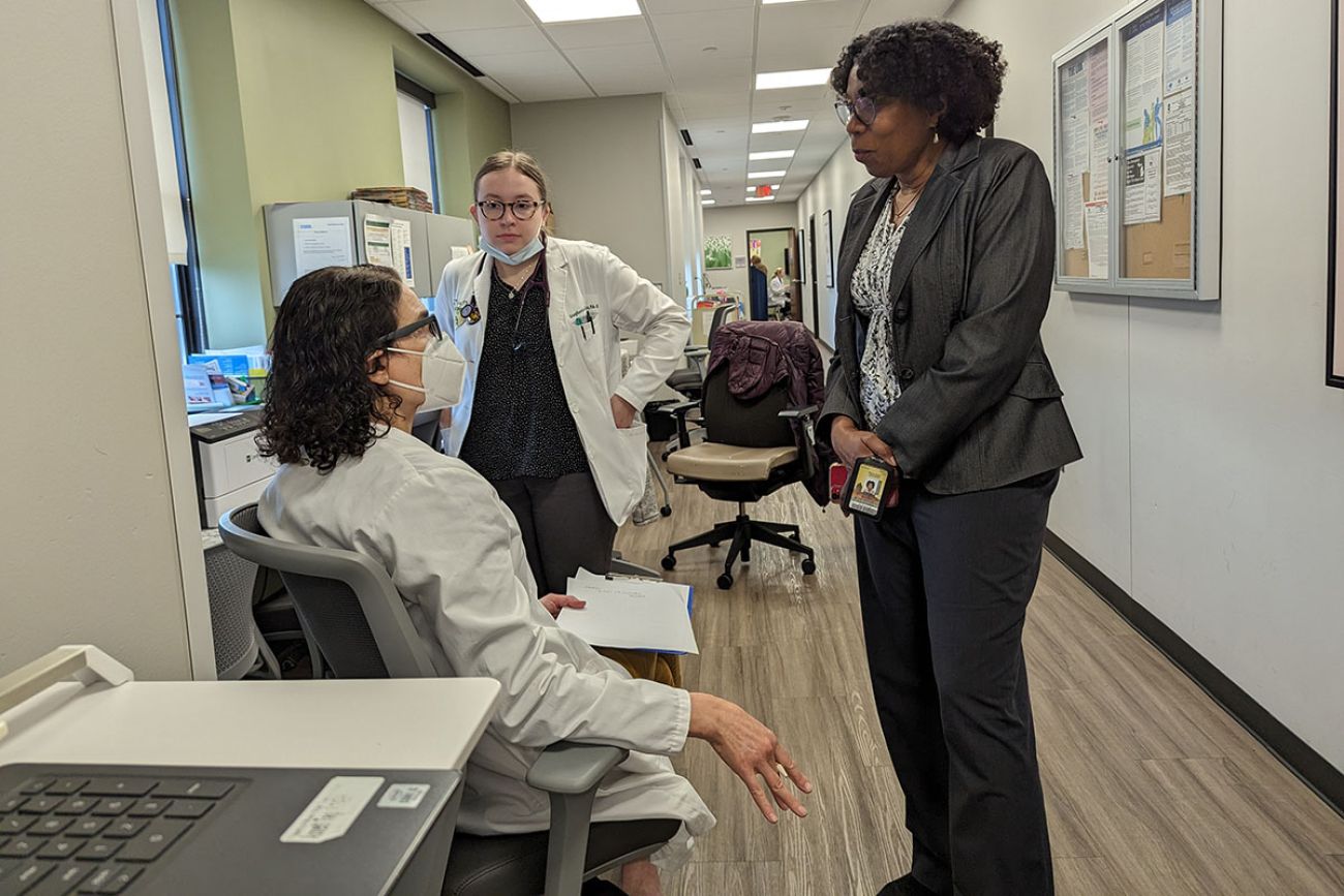 three people talking in a hallway in the clinic