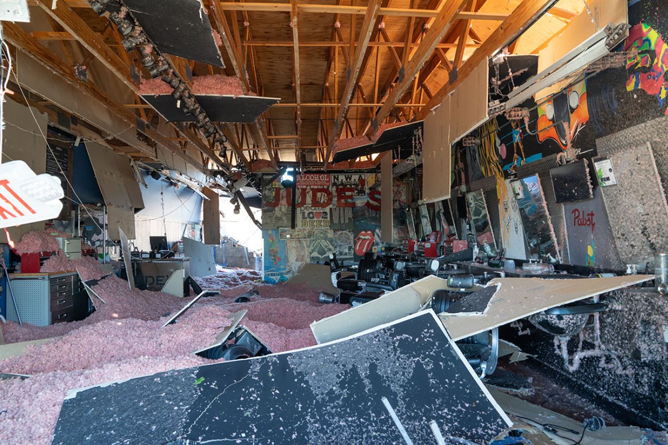 the inside of building is disheveled; you can see roof insulation on the floor