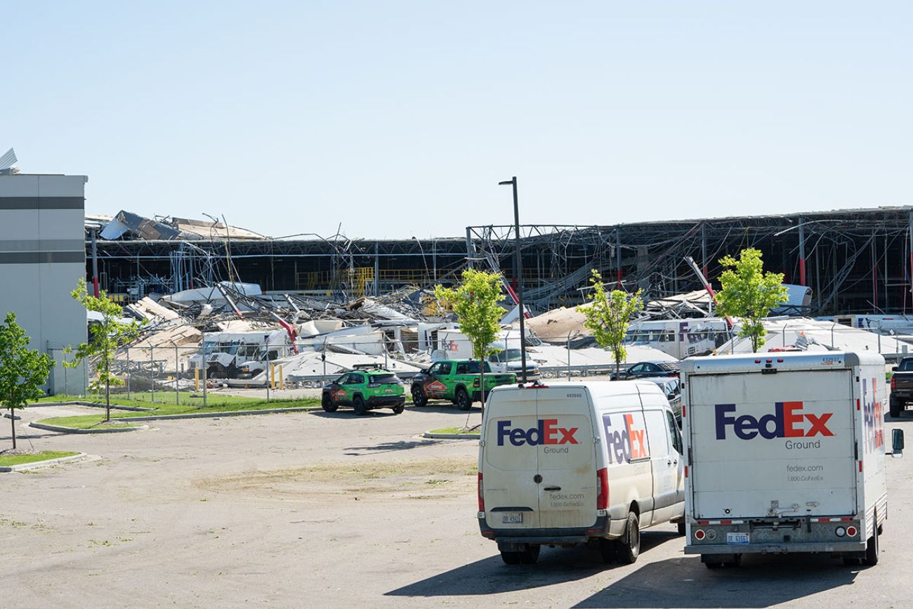 Two trucks in front of FedEx Ground facility. The roof is collapsed