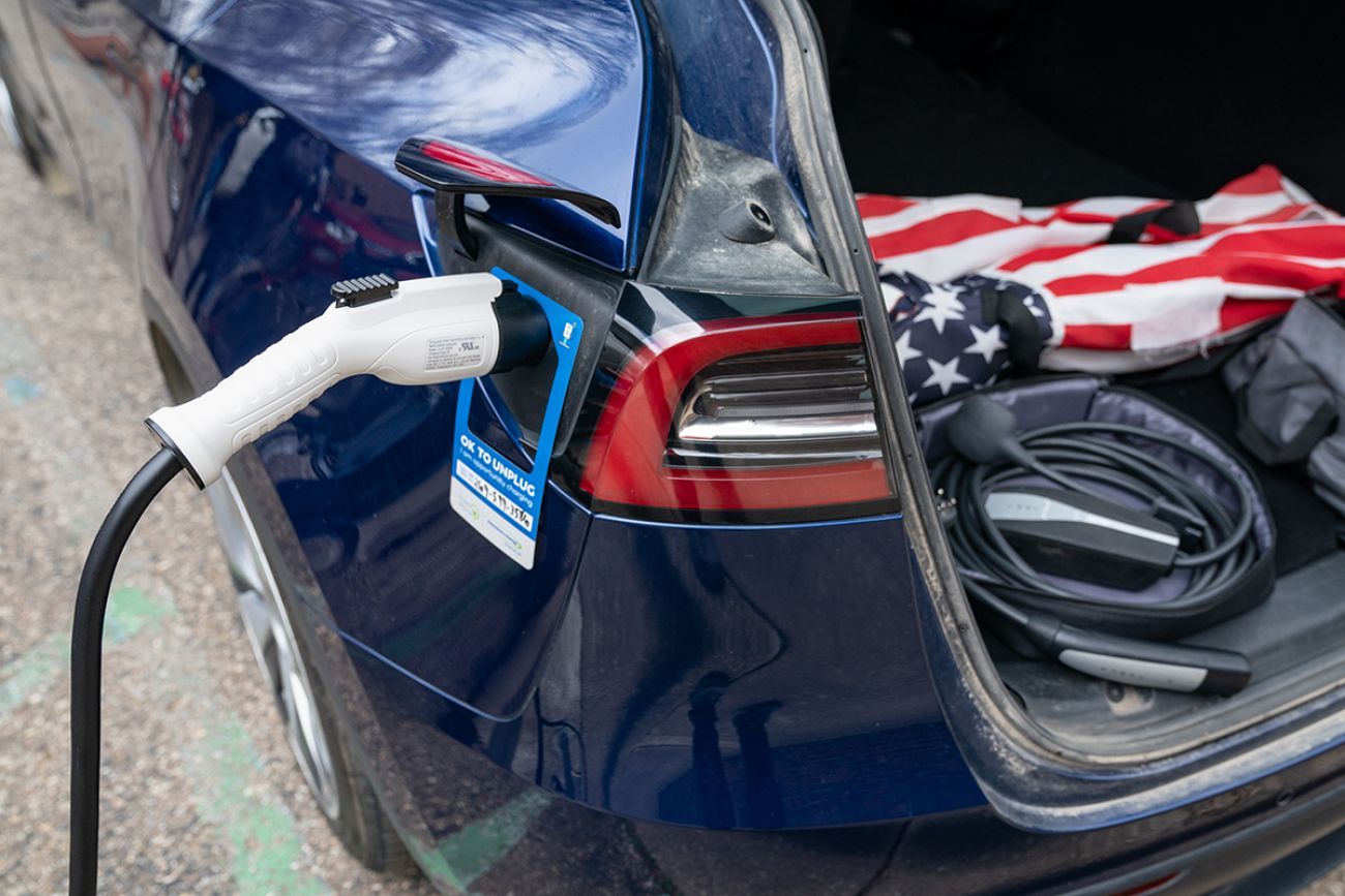 A blue EV being plugged in