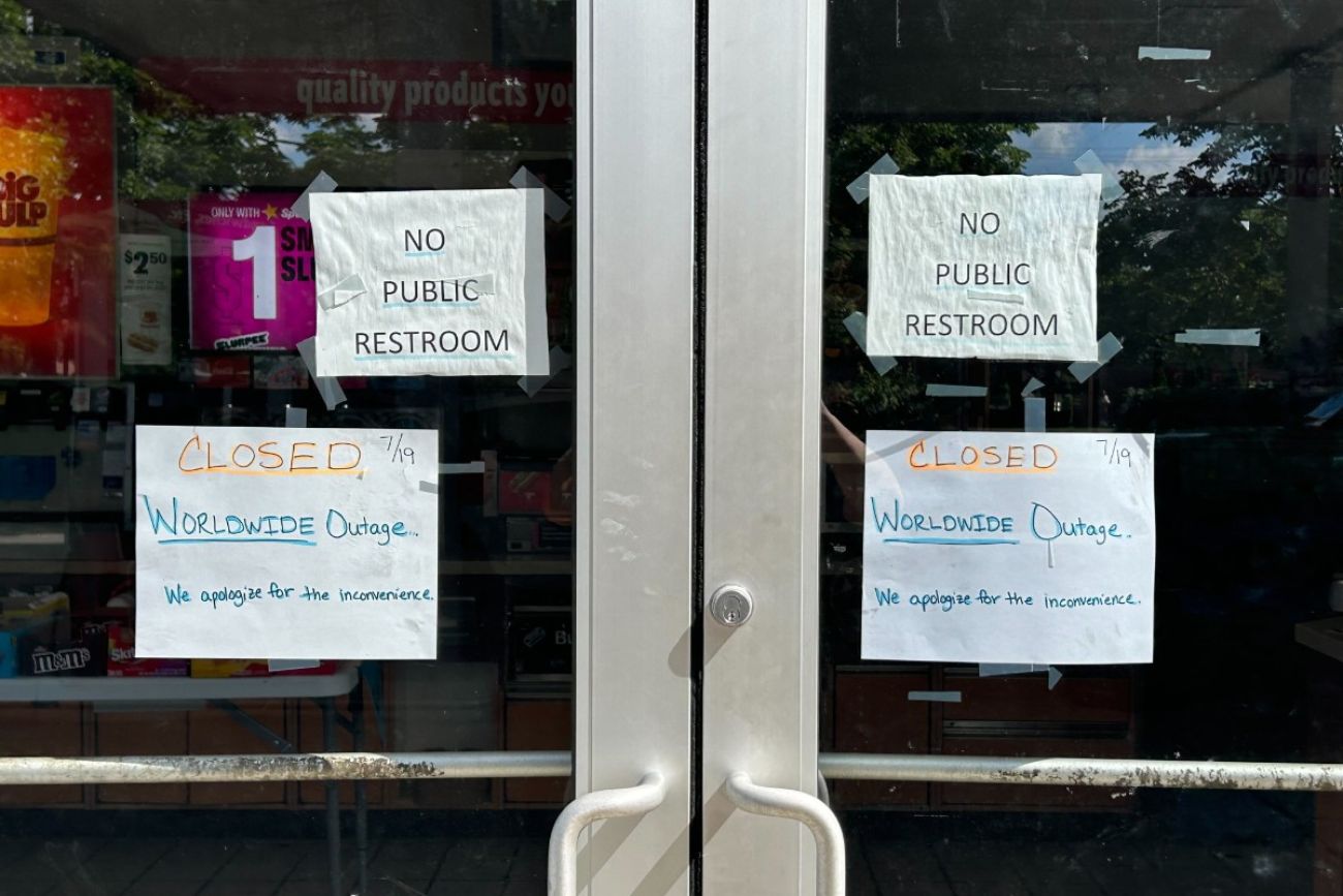A sign that says "Closed. Worldwide Outage. We apologize for any inconvenience" outside a gas station in Michigan.