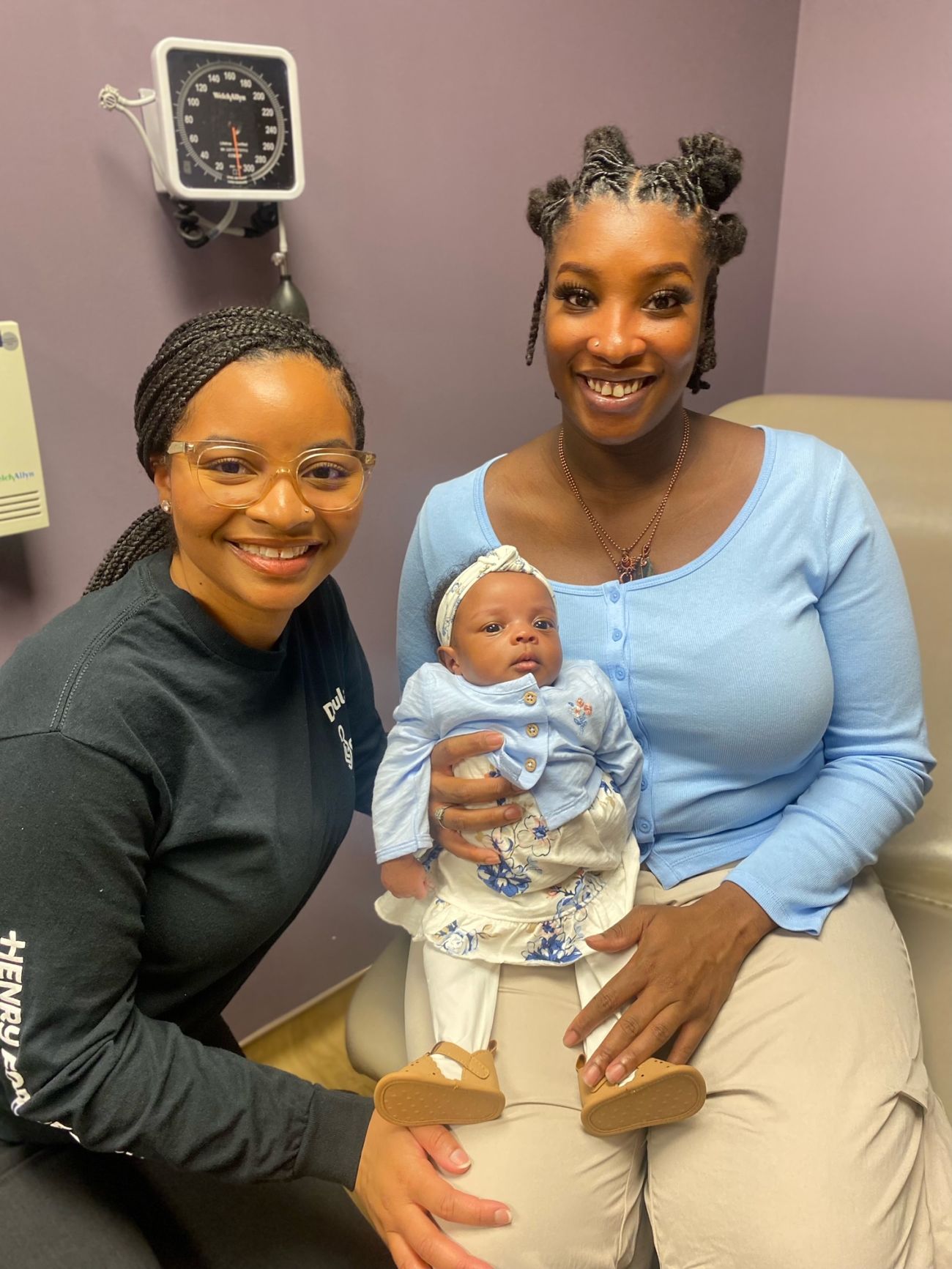 Two people holding a baby