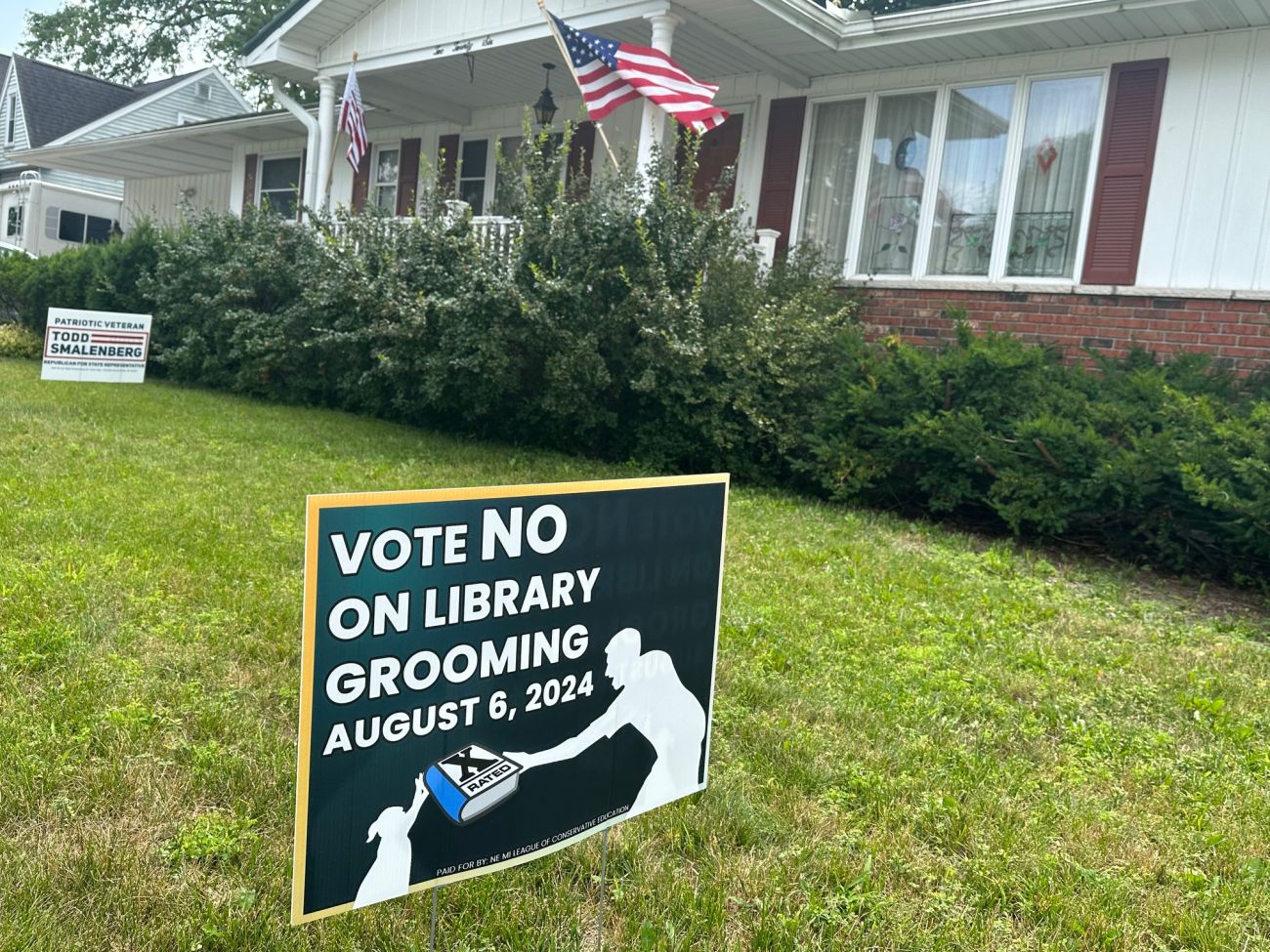 A sign in front of a house that says "Vote No On Library Grooming"