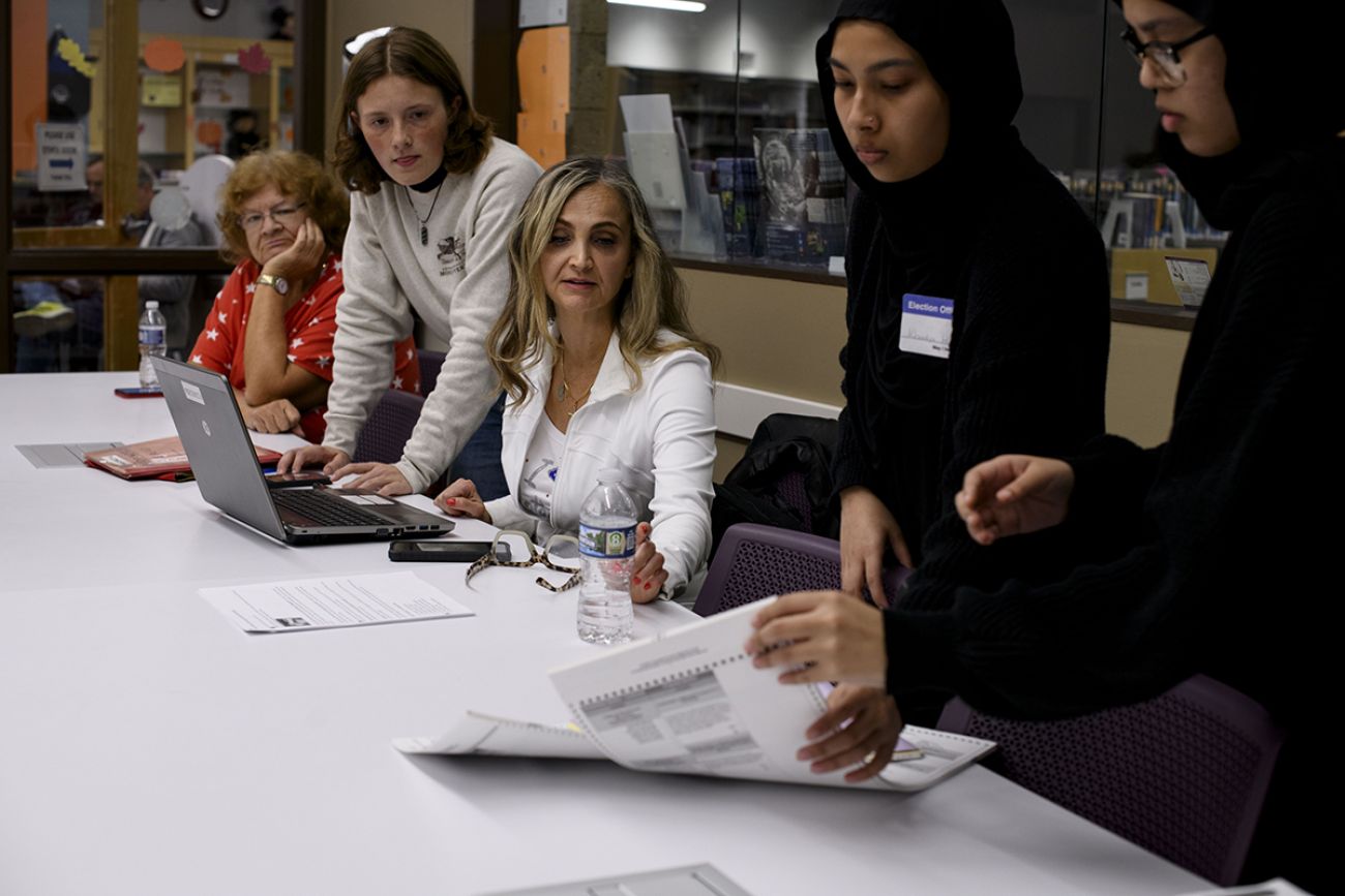 Warren City Clerk Sonja Djurovic Buffa sits at a table with other poll workers