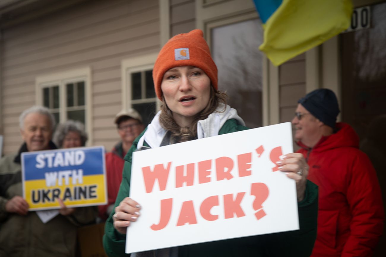 A woman holds a sign that says "Where's Jack?"